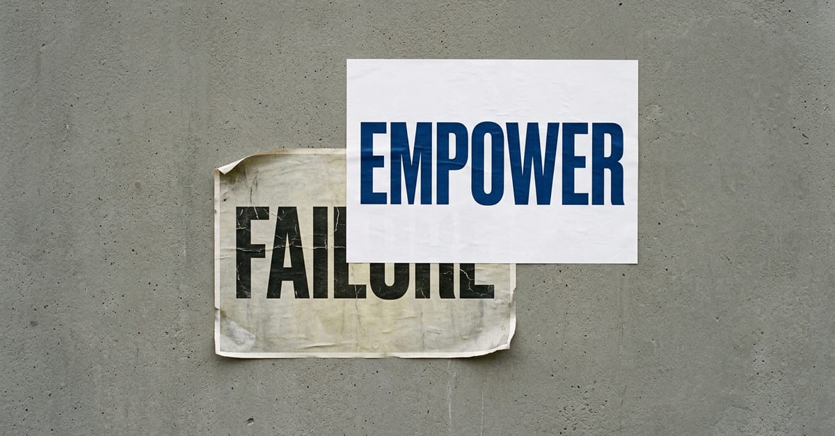 Two posters on a concrete wall: a clean new one reading EMPOWER pasted over an old, faded one reading FAILURE